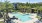 Large sparkling blue pool with a large pool deck and lounge chairs